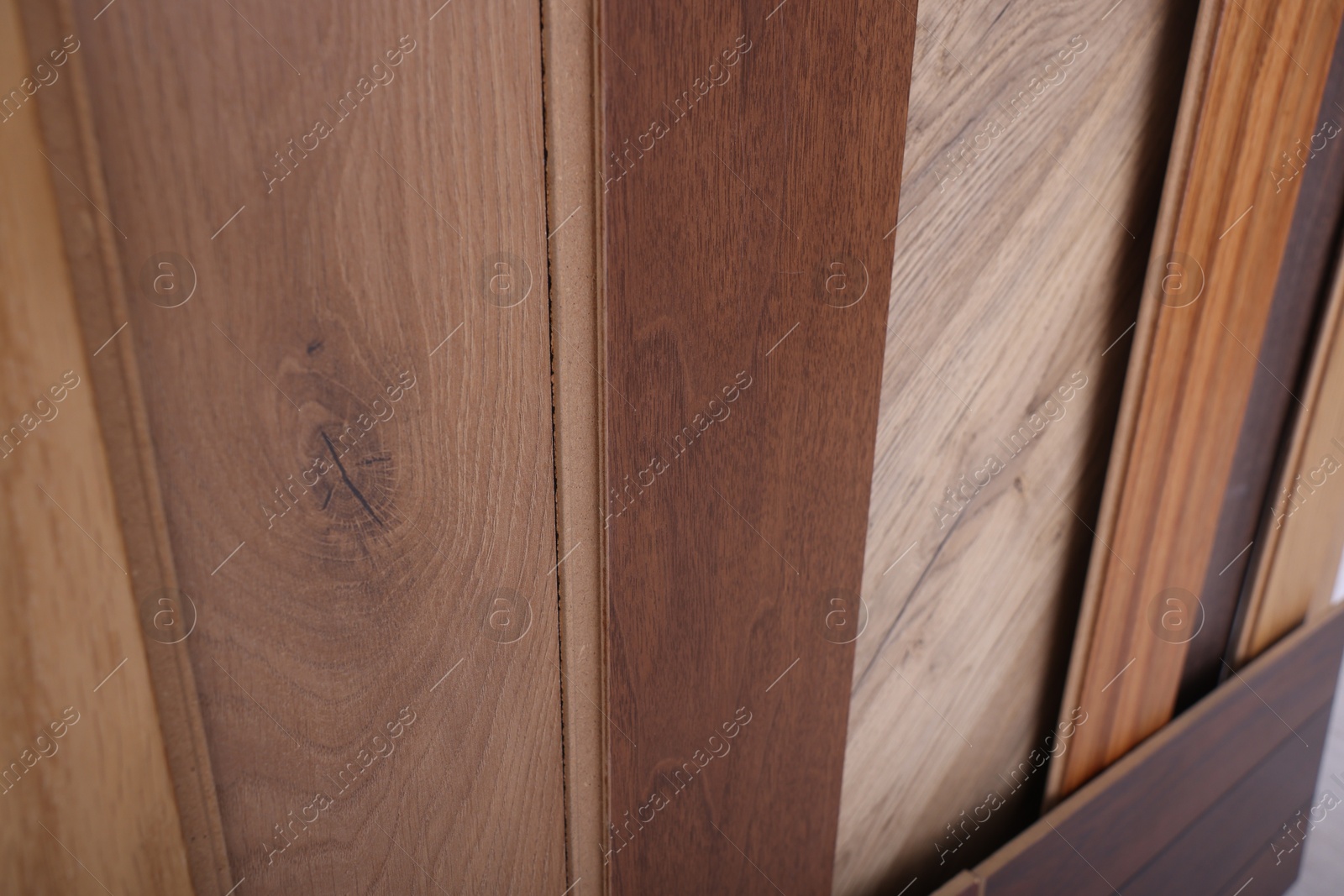 Photo of Many different samples of wooden flooring as background, closeup