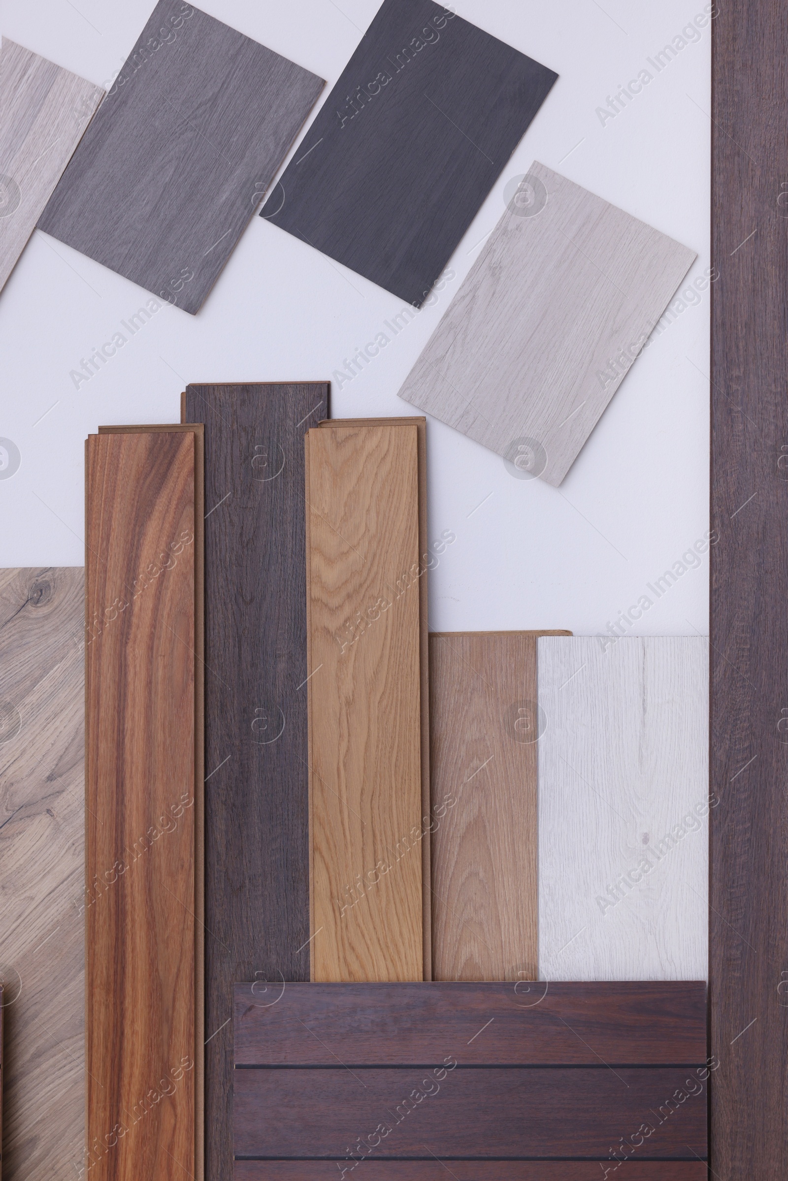 Photo of Many different samples of wooden flooring on light background