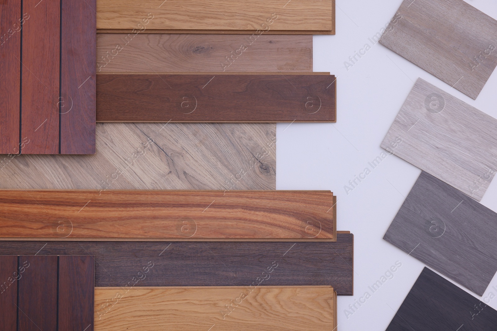 Photo of Many different samples of wooden flooring on light background