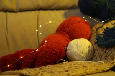 Knitting material. Skeins of soft yarn on sofa indoors