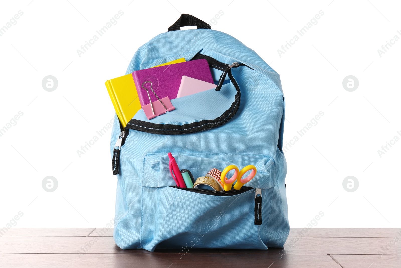 Photo of Backpack with different school stationery on wooden table against white background