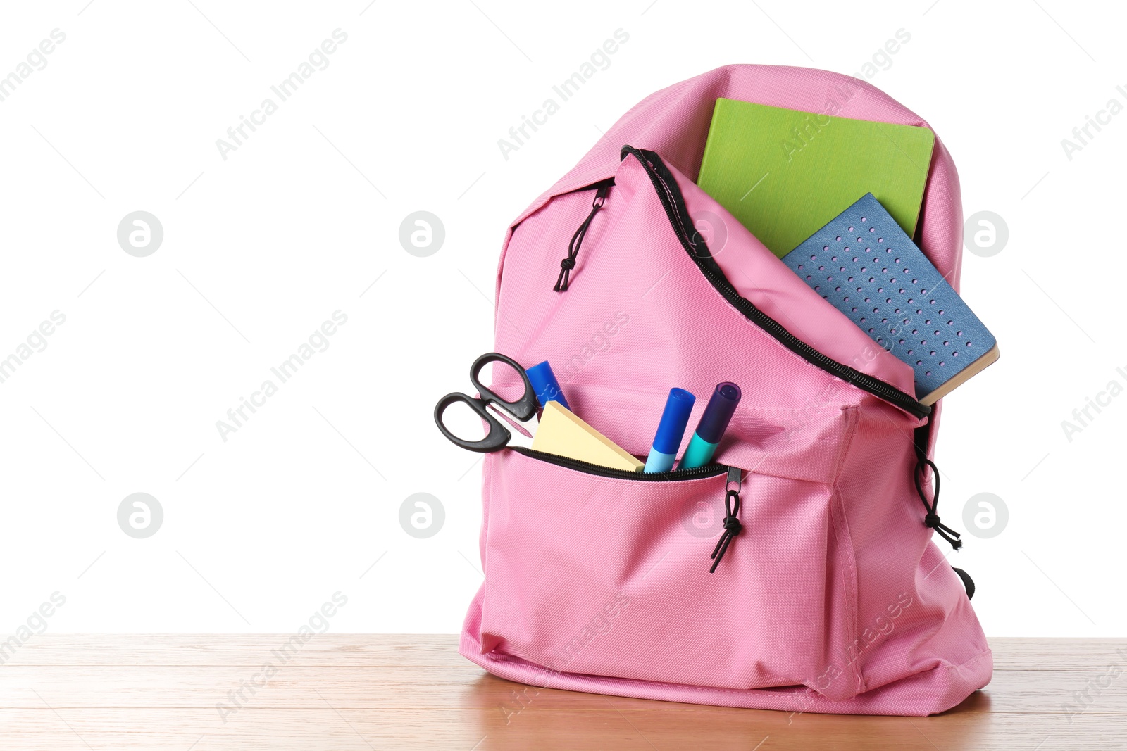 Photo of Backpack with different school stationery on wooden table against white background, space for text