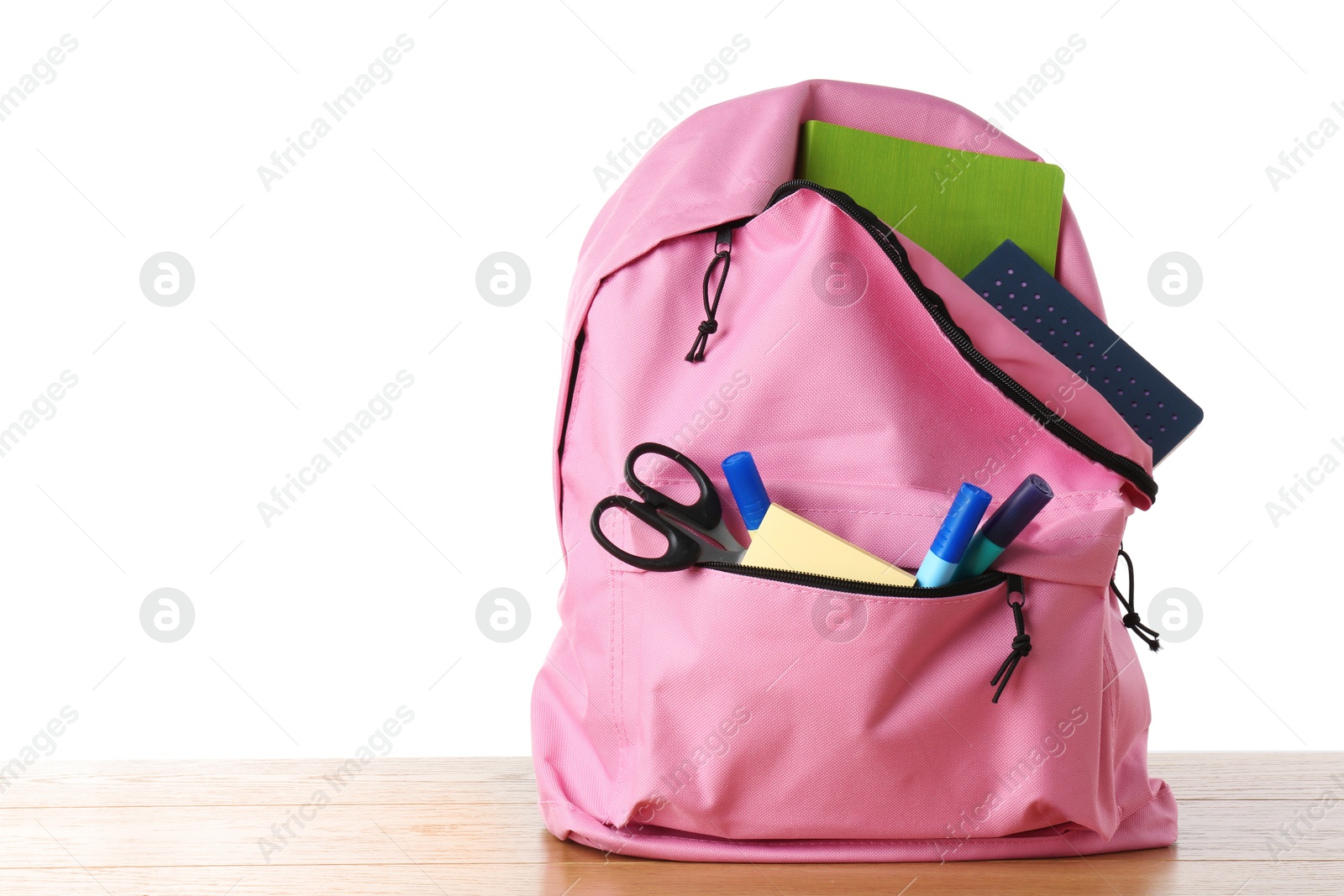 Photo of Backpack with different school stationery on wooden table against white background, space for text