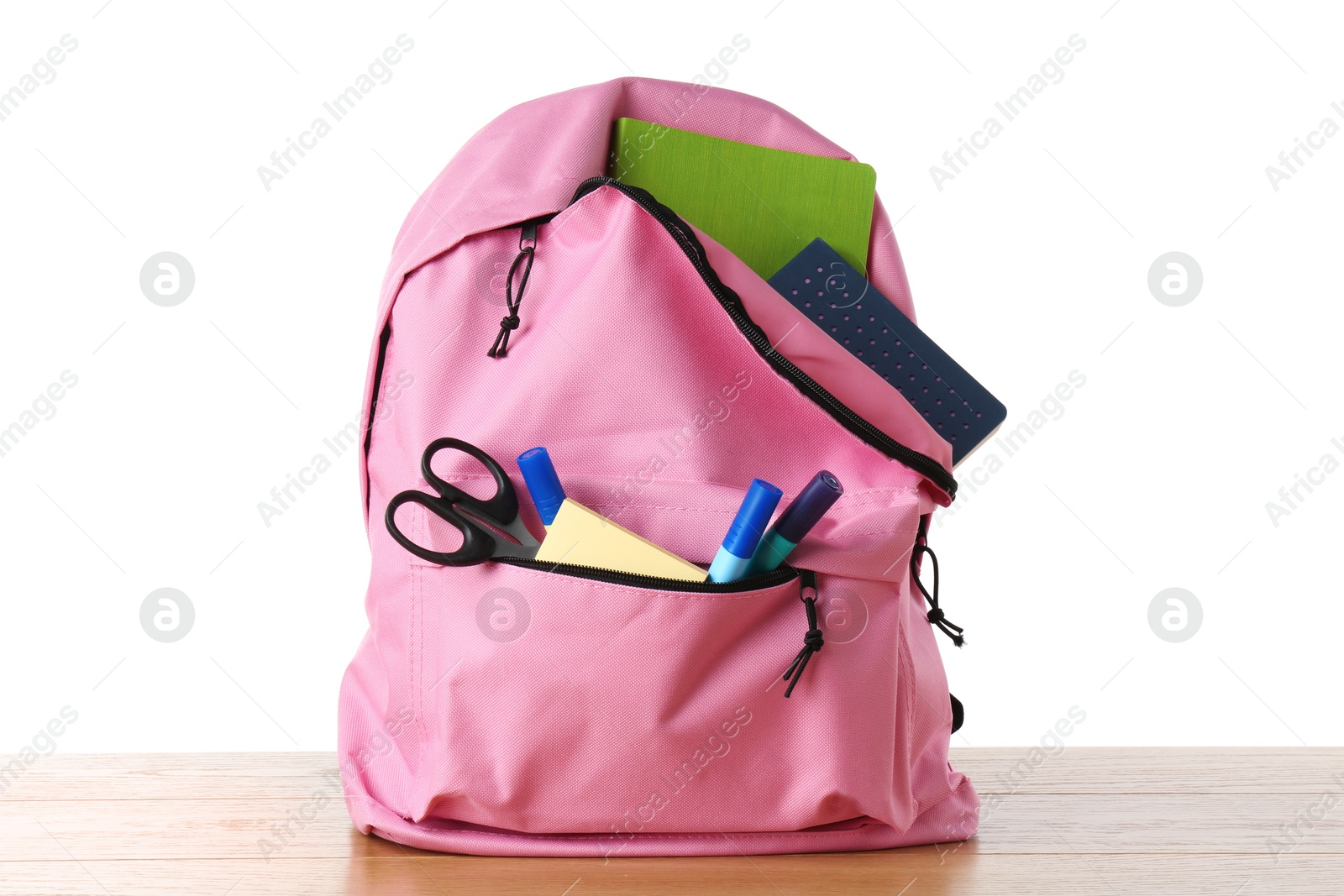 Photo of Backpack with different school stationery on wooden table against white background