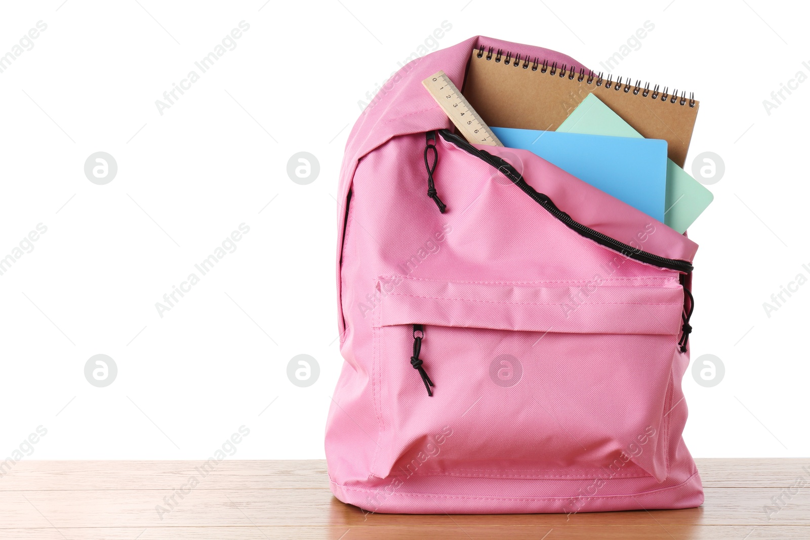 Photo of Backpack with notebooks and ruler on wooden table against white background, space for text