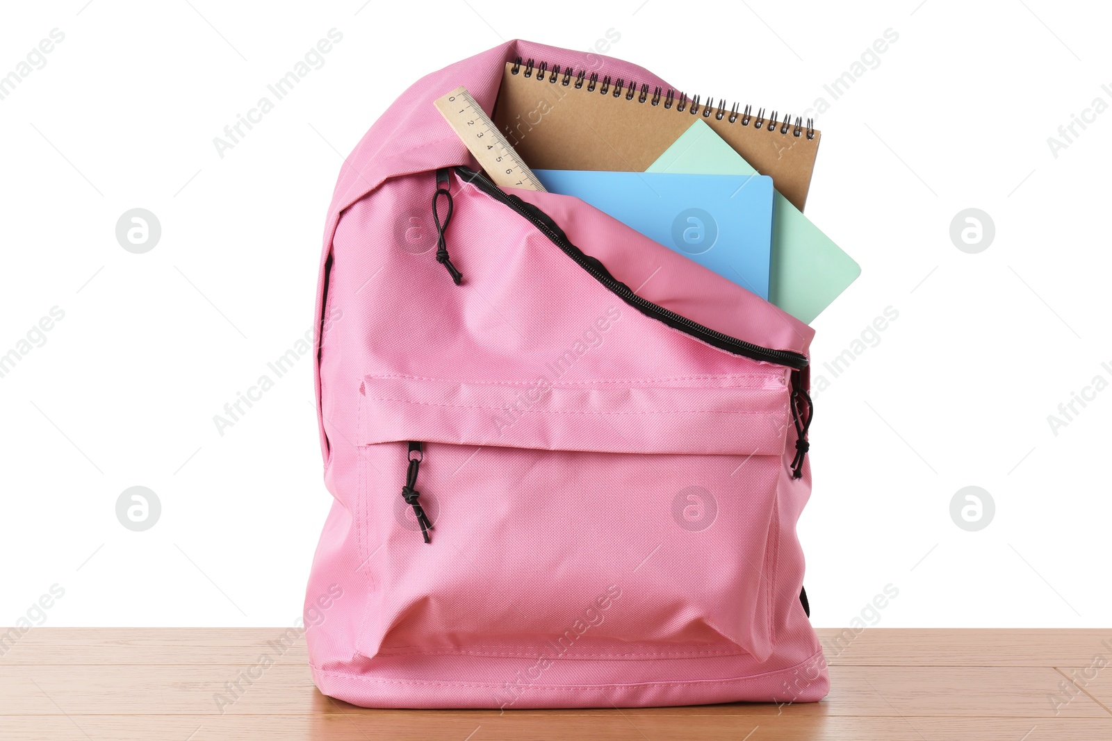 Photo of Backpack with notebooks and ruler on wooden table against white background