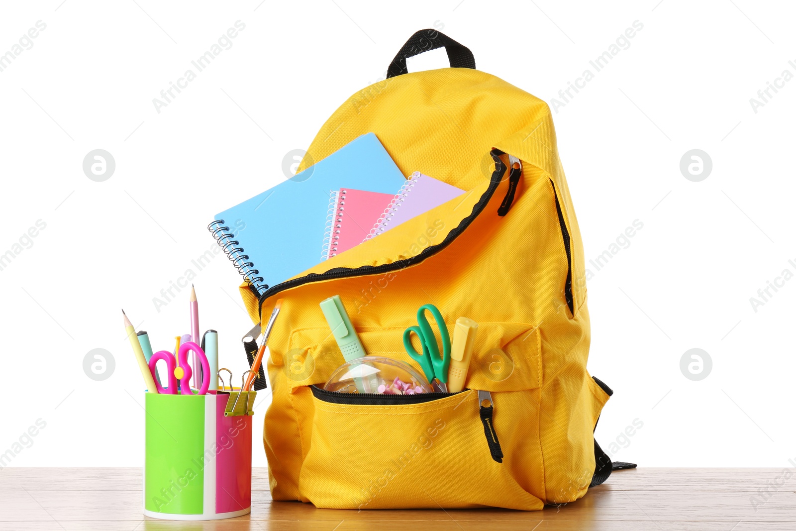 Photo of Backpack with different school stationery on wooden table against white background