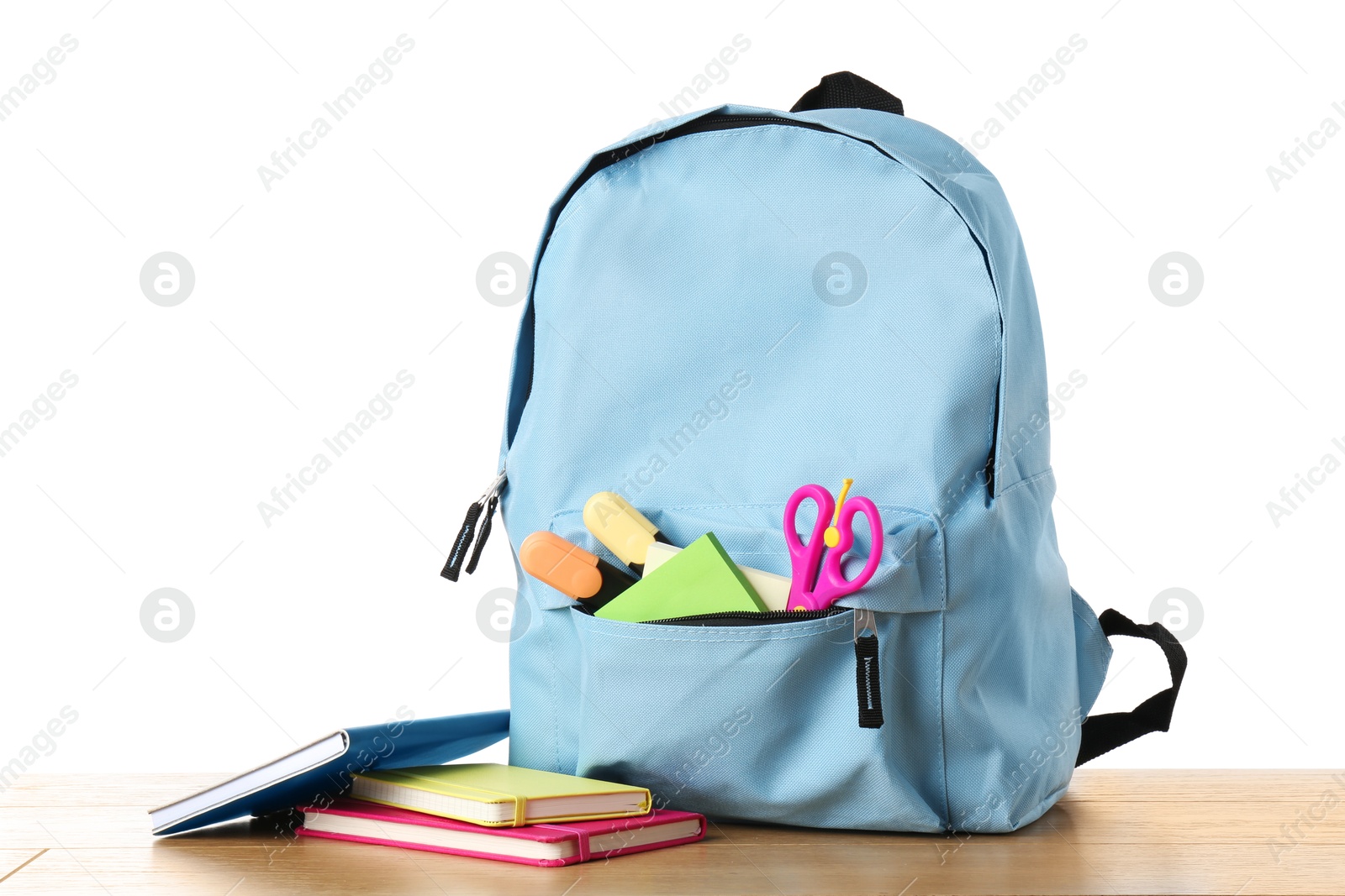 Photo of Backpack with different school stationery on wooden table against white background