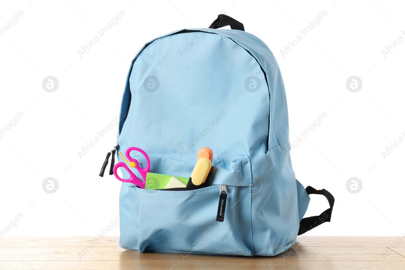 Photo of Backpack with different school stationery on wooden table against white background