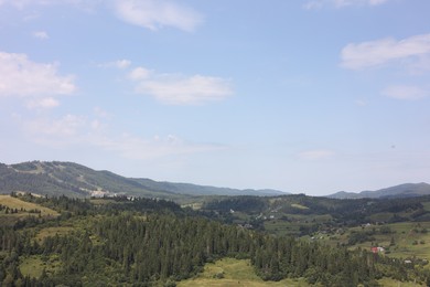 Photo of Picturesque view of forest in mountains under blue sky