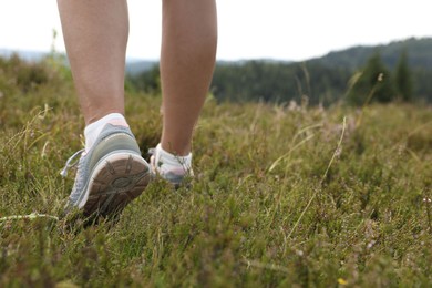 Photo of Woman hiking in mountains, closeup. Space for text