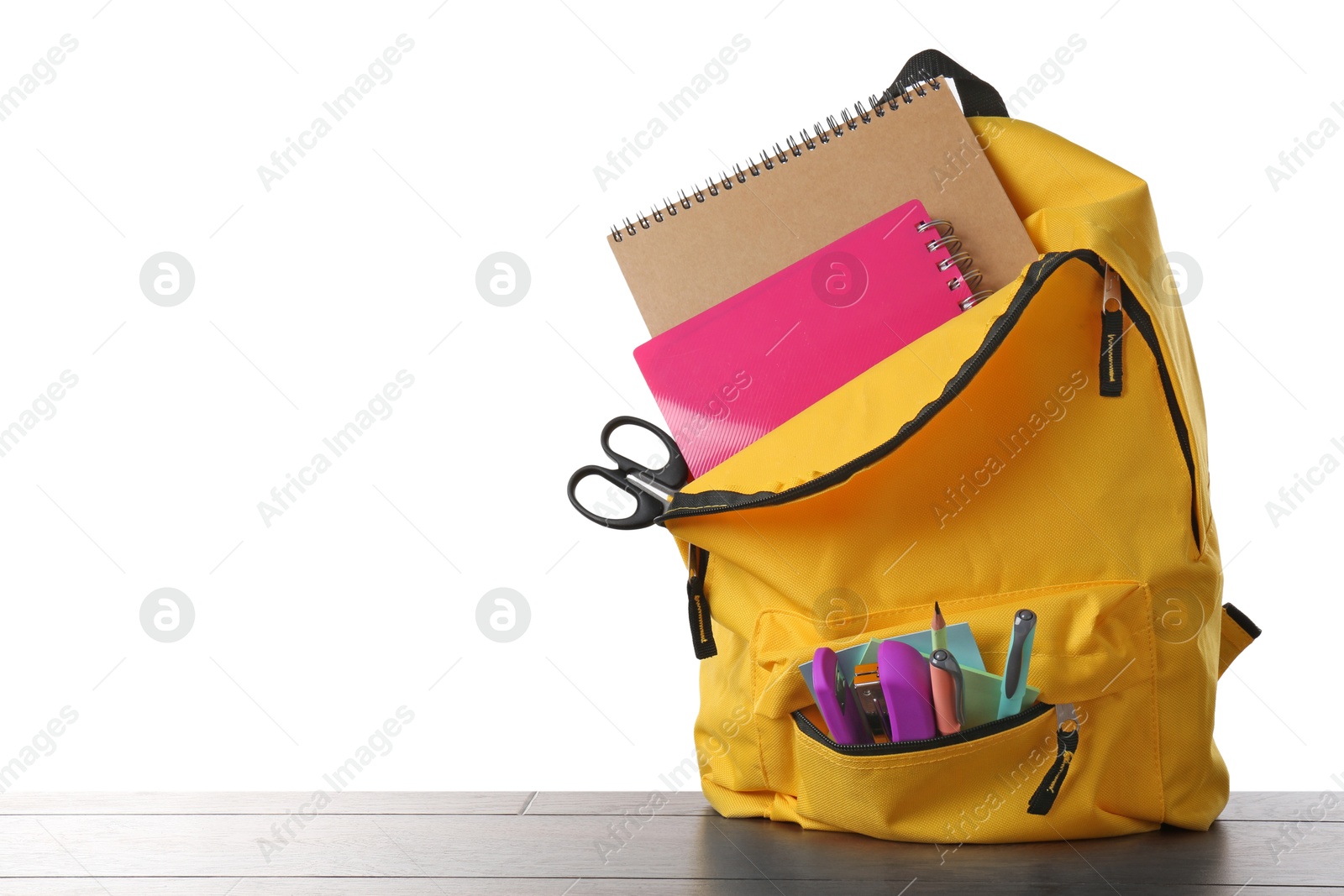 Photo of Backpack with different school stationery on wooden table against white background, space for text