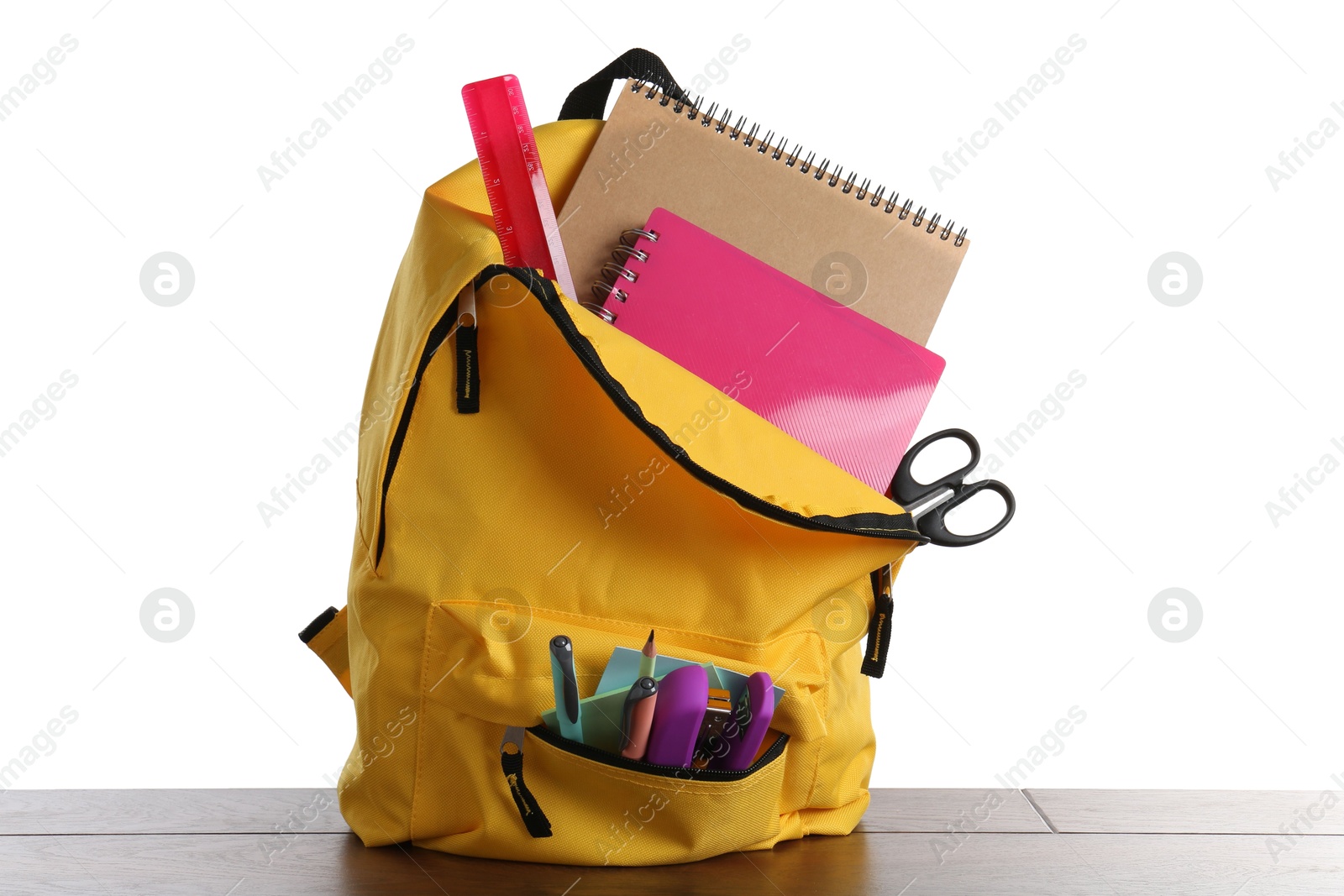 Photo of Backpack with different school stationery on wooden table against white background