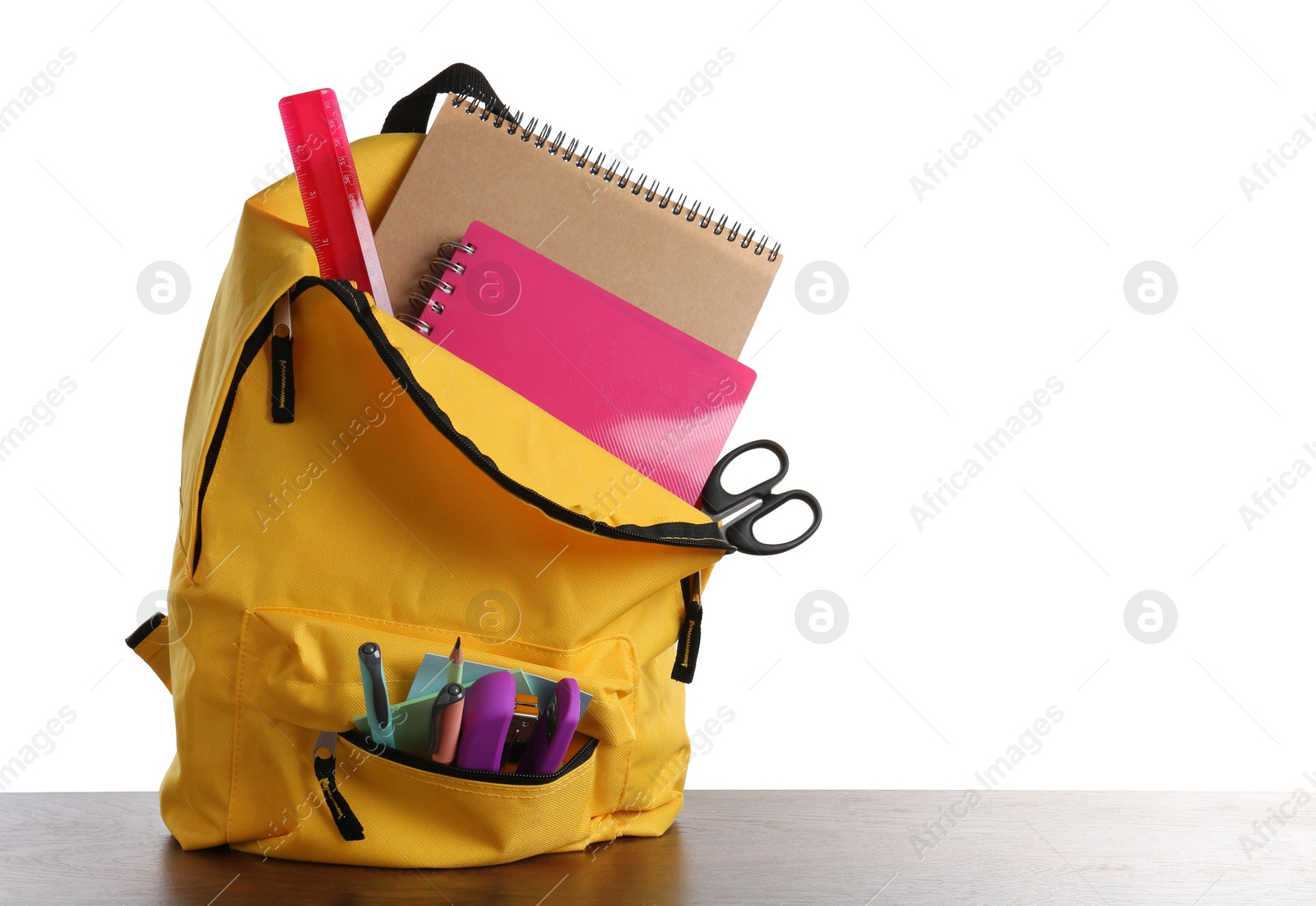 Photo of Backpack with different school stationery on wooden table against white background, space for text