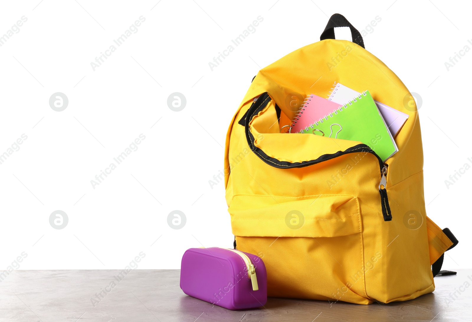 Photo of Backpack with different school stationery on gray textured table against white background, space for text