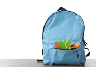 Photo of Backpack with different school stationery on gray textured table against white background, space for text