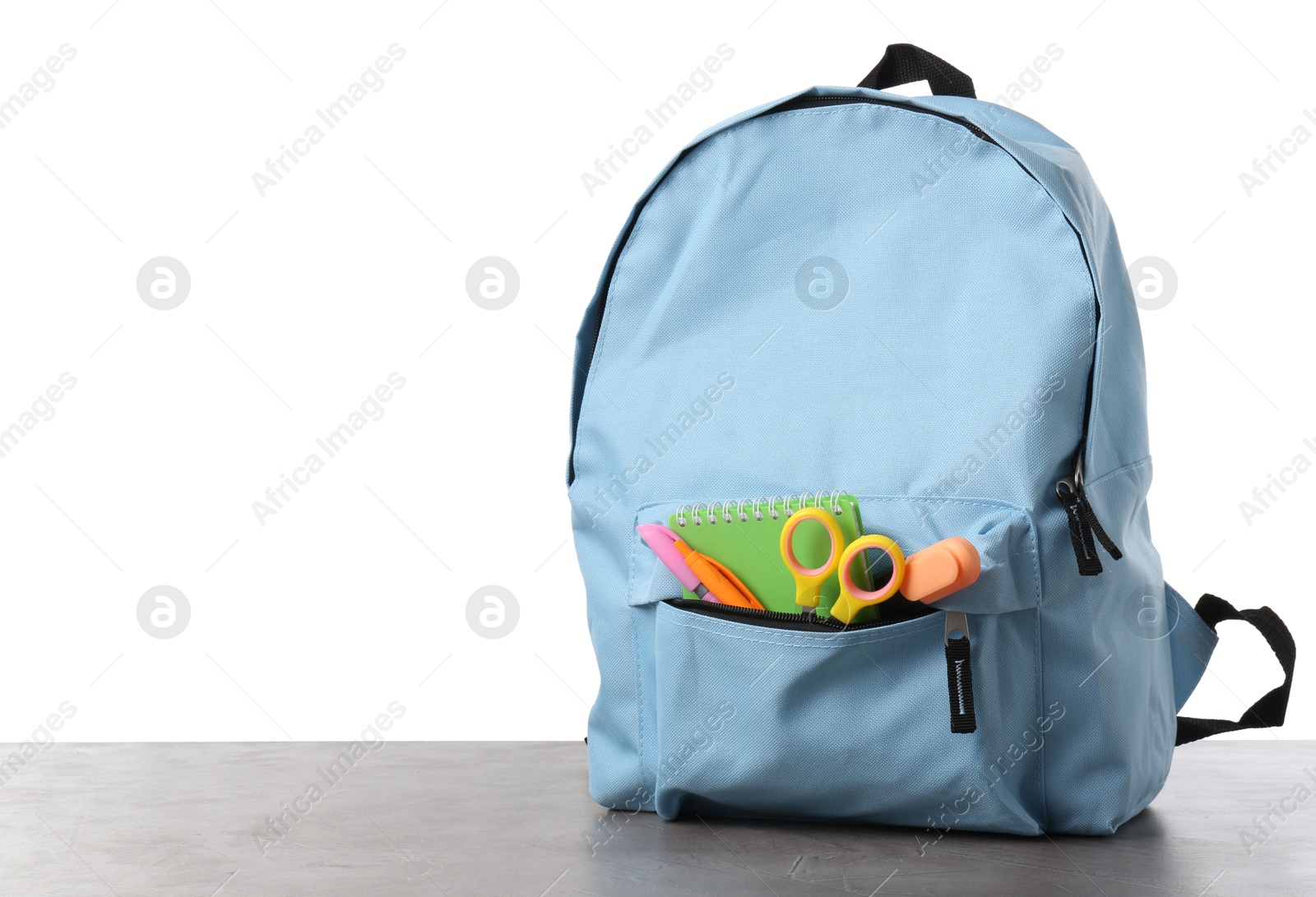 Photo of Backpack with different school stationery on gray textured table against white background, space for text