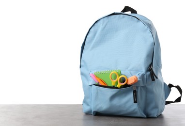 Photo of Backpack with different school stationery on gray textured table against white background, space for text