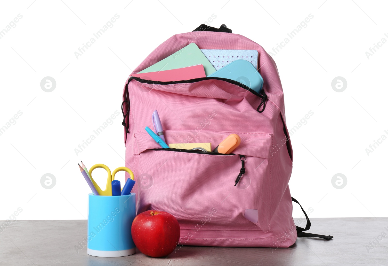 Photo of Backpack with different school stationery and apple on gray textured table against white background