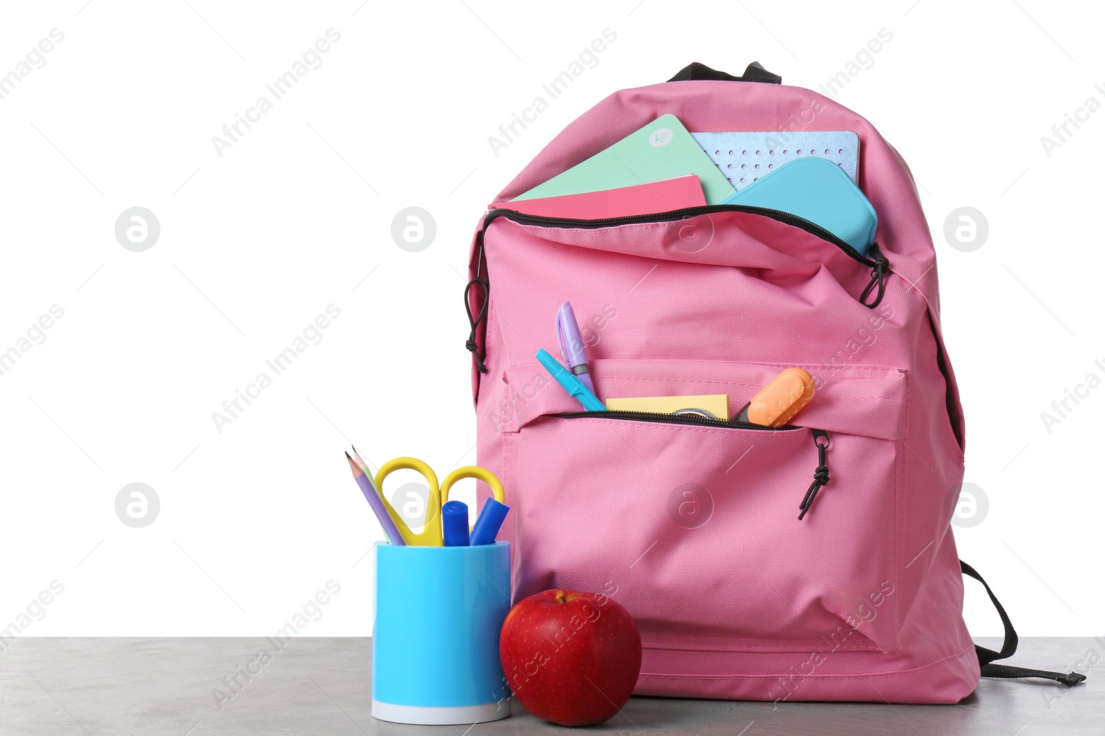 Photo of Backpack with different school stationery and apple on gray textured table against white background, space for text