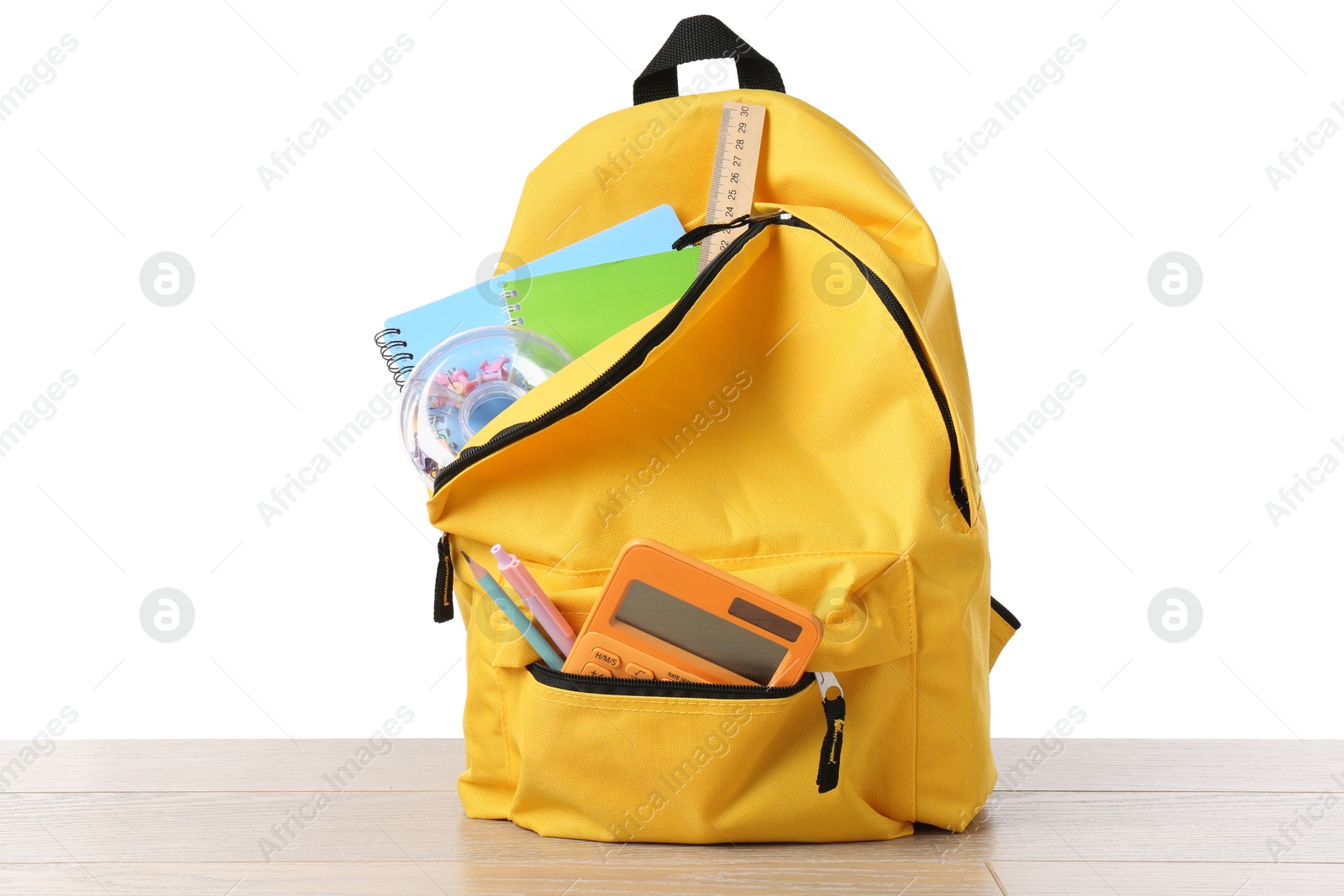 Photo of Backpack with different school stationery on wooden table against white background