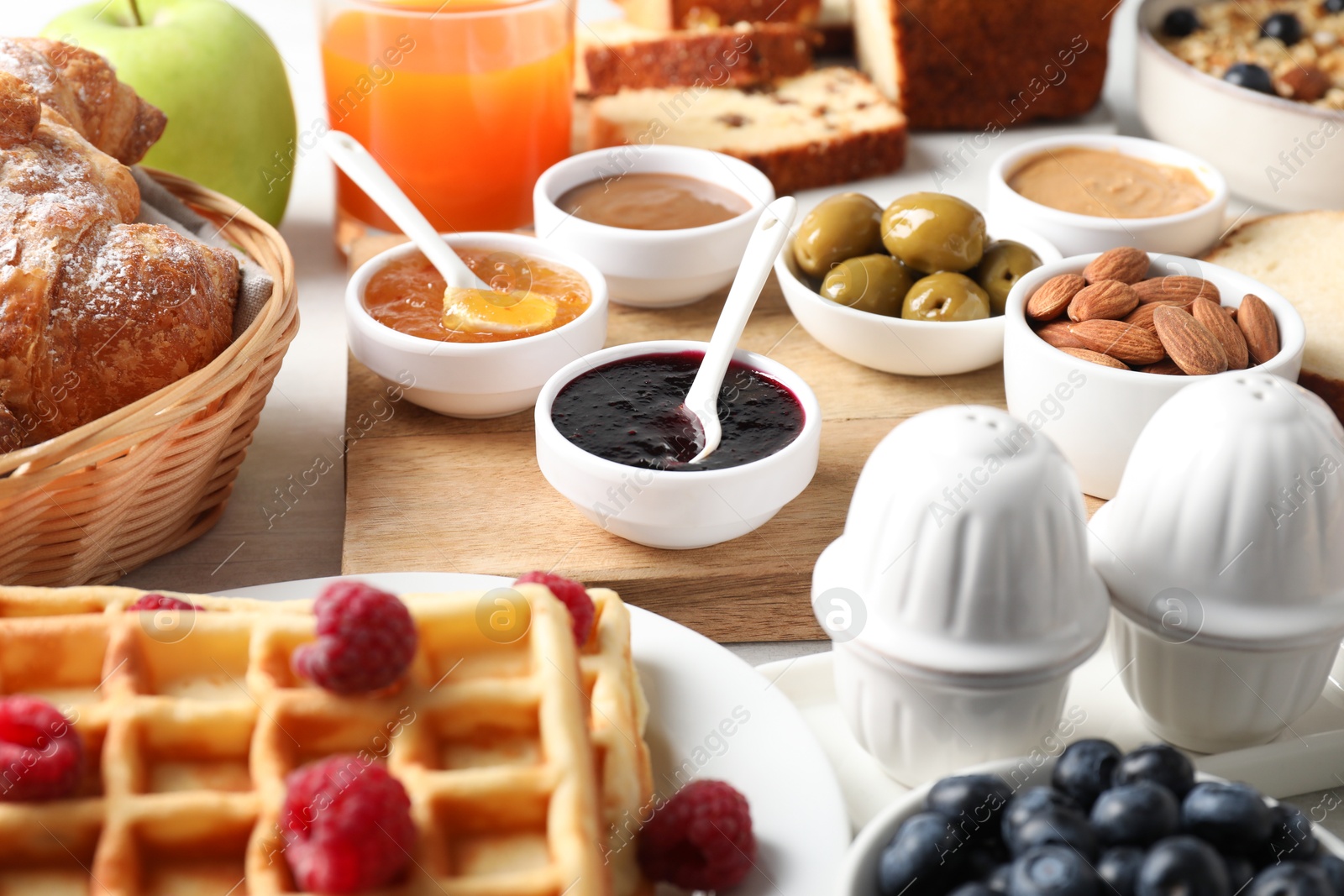 Photo of Different meals served for breakfast on white table, closeup. Buffet menu