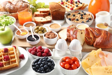 Photo of Different meals served for breakfast on white table