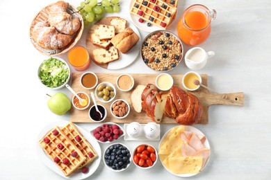 Photo of Different meals served for breakfast on white table, flat lay