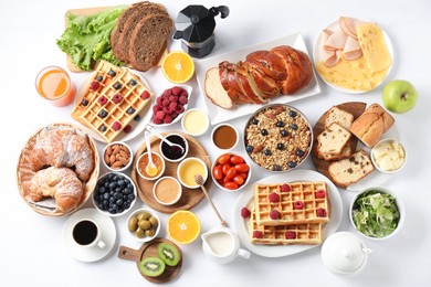 Photo of Different meals served for breakfast on white table, flat lay