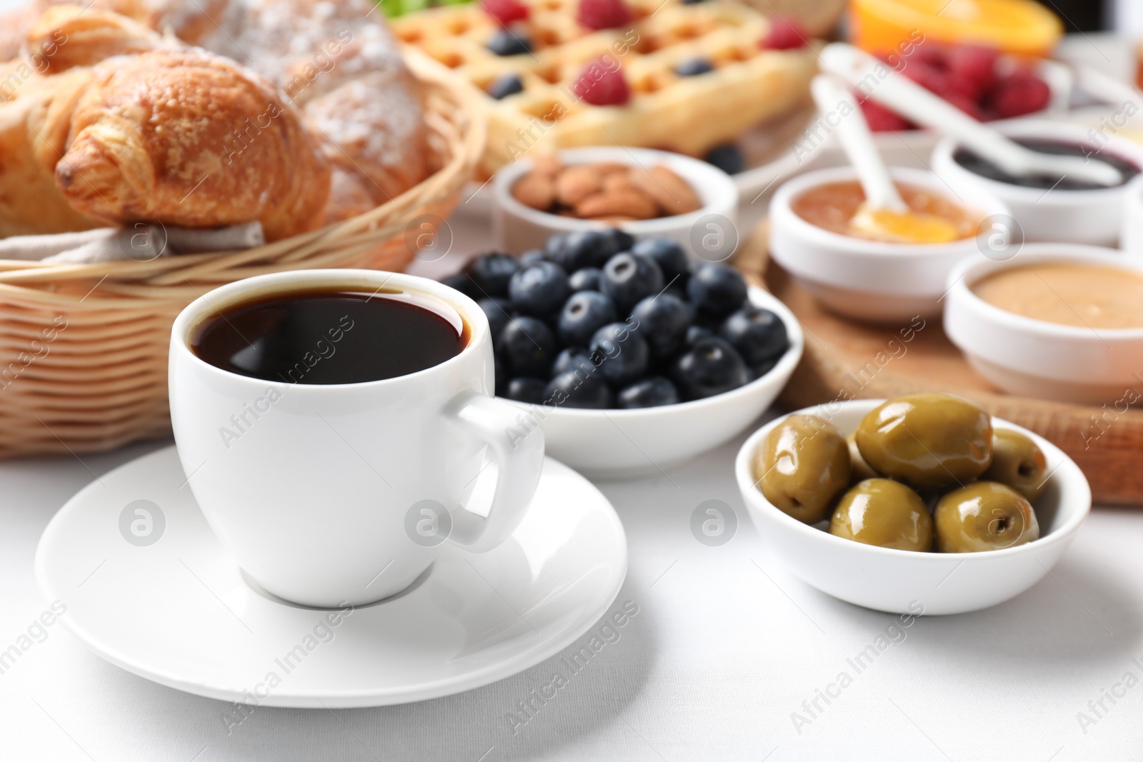 Photo of Cup of coffee and different meals served for breakfast on white table