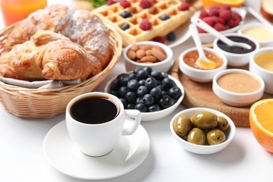 Photo of Cup of coffee and different meals served for breakfast on white table