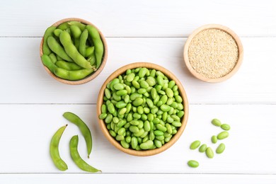 Fresh edamame soybeans, pods and seeds on white wooden table, flat lay