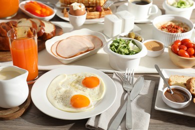 Photo of Different meals served for breakfast on wooden table