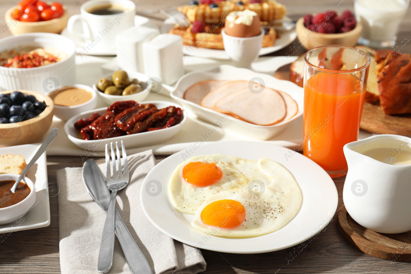 Photo of Different meals served for breakfast on wooden table