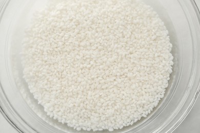 Photo of Raw rice in bowl with water, top view