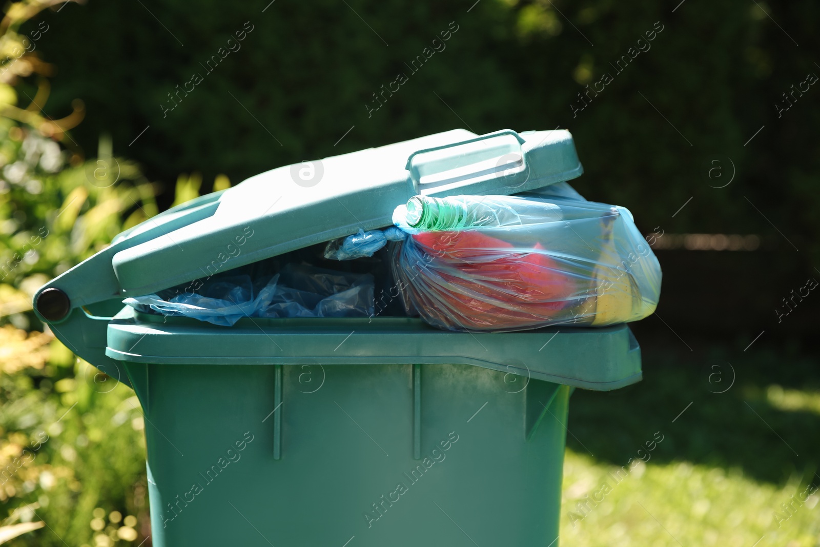 Photo of Trash bags in garbage bin outdoors, closeup