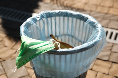 Photo of Trash bag with garbage in bin outdoors, closeup