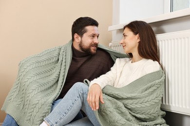 Happy couple near heating radiator at home