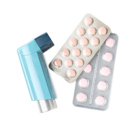 Photo of Asthma treatment. Inhaler and pills isolated on white, top view