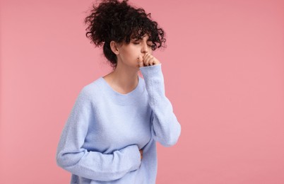 Cold symptom. Young woman suffering from illness on pink background, space for text