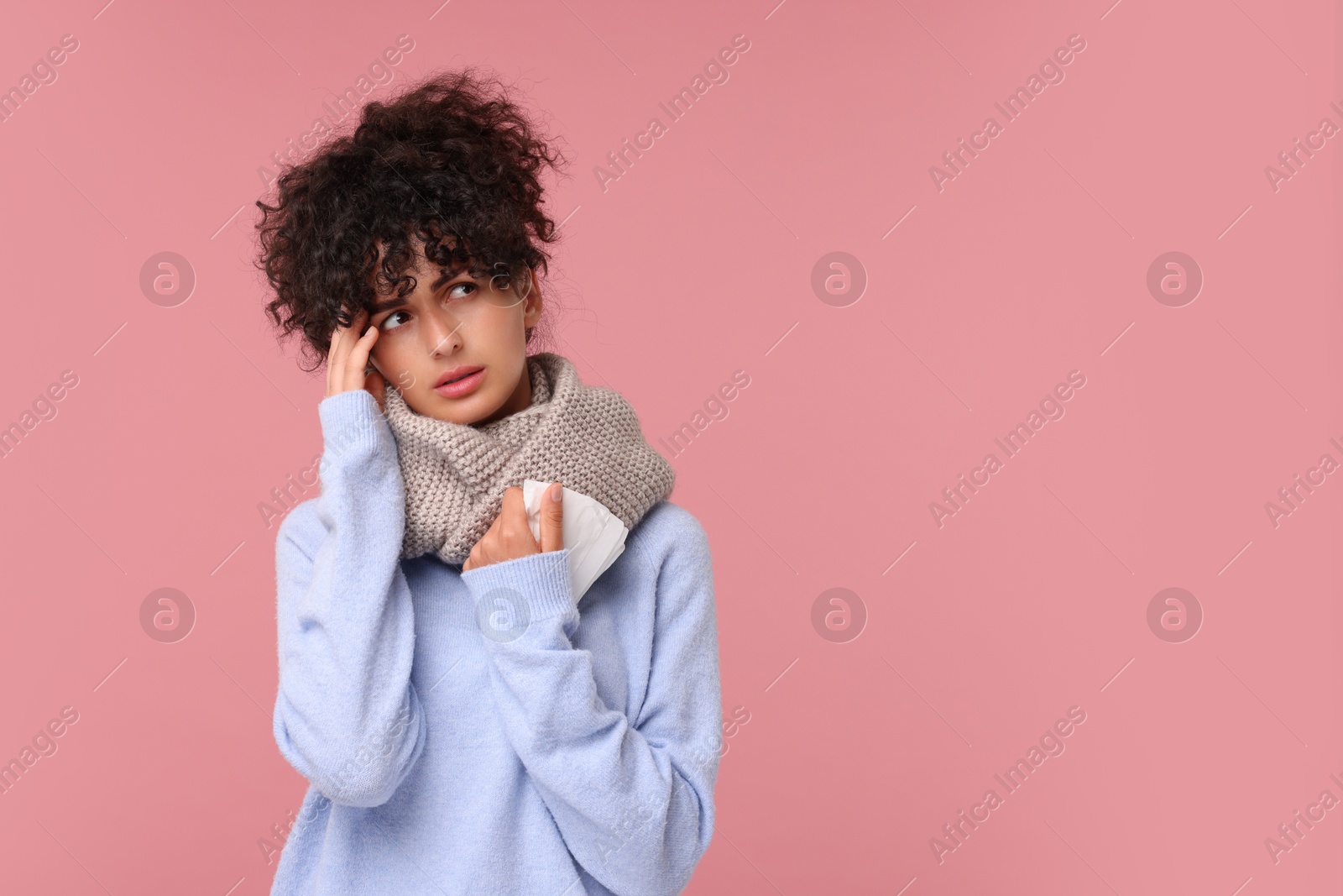 Photo of Cold symptom. Young woman with tissue on pink background, space for text