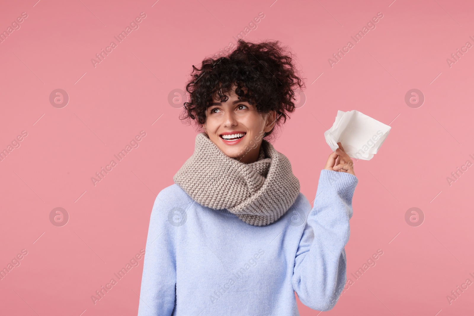 Photo of Cold symptom. Happy young woman with tissue on pink background