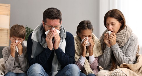 Photo of Cold symptom. Family suffering from fever on sofa at home