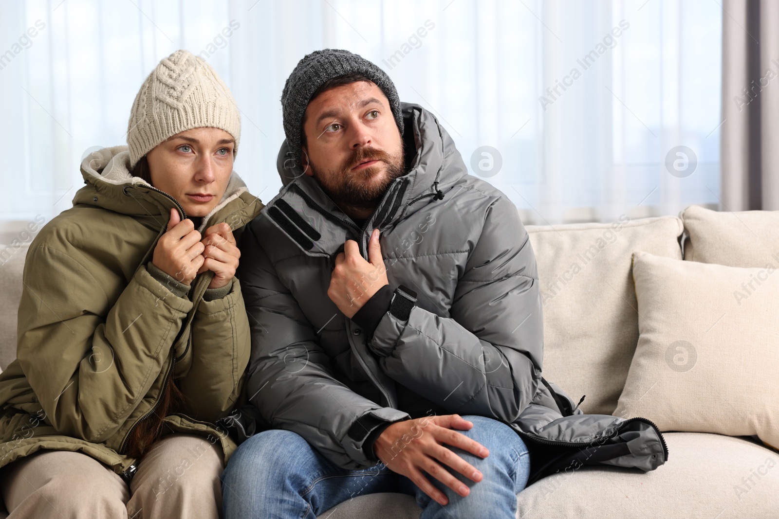 Photo of Cold symptom. Couple suffering from fever on sofa at home