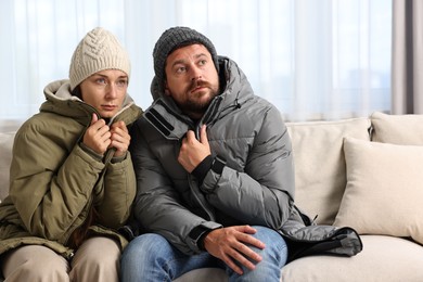 Photo of Cold symptom. Couple suffering from fever on sofa at home