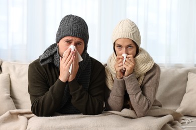 Cold symptom. Couple suffering from fever on sofa at home