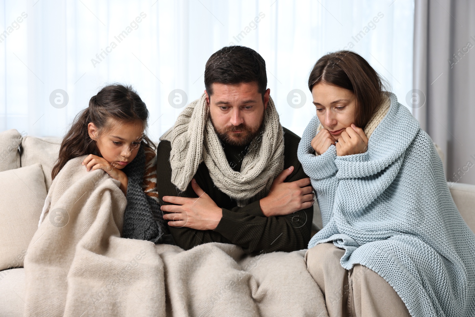 Photo of Cold symptom. Family suffering from fever on sofa at home