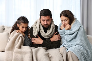 Cold symptom. Family suffering from fever on sofa at home