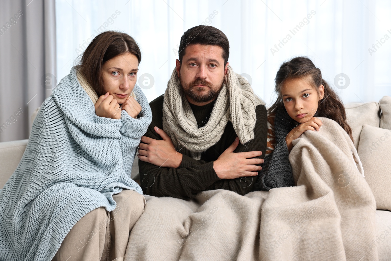 Photo of Cold symptom. Family suffering from fever on sofa at home