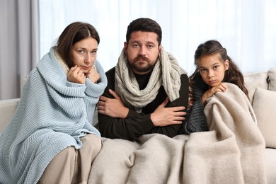 Cold symptom. Family suffering from fever on sofa at home